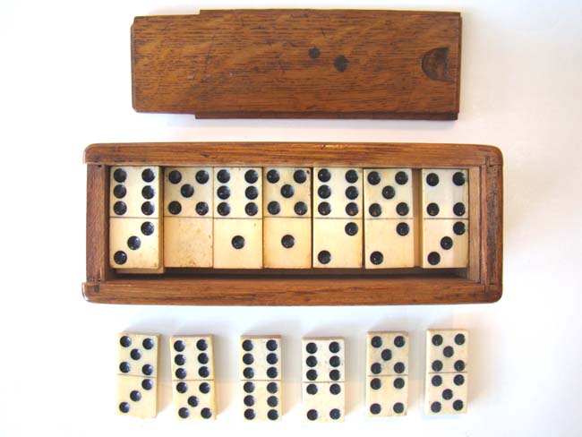 A fine set of solid bone antique 19th century dominoes in the original box